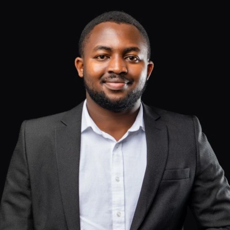 Man smiling at the camera wearing a suit